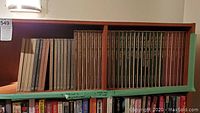 Wide view of two shelves filled with hard cover books, mostly Time Life series Great Ages of Man and Library of Art, showing uniform cloth bound in greys, browns, and greens, spines embossed in gold.