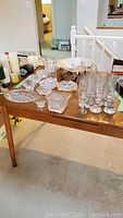 Wide view of the table displaying all items including vase, condiment dishes, ashtray, water jug, and glasses