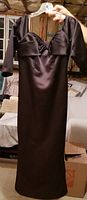 Photo of the black silk gown with sweetheart neckline, hung on a hanger showing full length and bodice details.