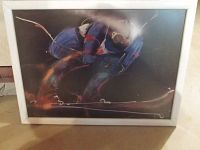 Framed artwork poster of a skier in slalom skiing position with abstract dynamic strokes in color