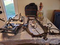 Overview of lot items including snowshoes, horse harness, black bag, tape measure, puck, glass insulators, and Crown Royal lamp.