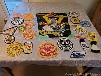 Photo showing 21 assorted patches spread out on a table including a large ZZ Top patch and various vintage club and tournament patches.