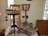 Overview of lot showing fern stand, windmill, metallic box with electric knife on top, heat registers, and packages on table.