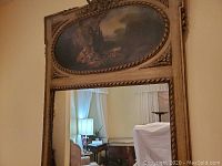 Full view of mirror and frame mounted on wall, reflecting interior furniture