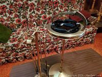 Complete ash tray stand with attached black glass ash tray and handle, and three fireplace poker tools standing beside it.