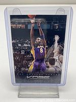 Front view of the 2012-13 Panini Anthology Kobe Bryant basketball card showing Kobe mid-air in Lakers jersey, enclosed in a protective plastic holder.