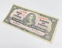 Front side of the 1937 Canadian ten dollar banknote showing King George VI portrait, signatures, serial number J/D3239091 in red ink, denomination markings, and detailed engraving.