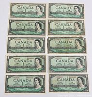 Front side of 10 Bank of Canada 1954 one dollar banknotes with portraits of Queen Elizabeth II and serial numbers.