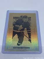 Back side of the gold etchings hockey card showing gold holographic finish with black and white image of player and series information.