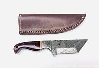 Mini tanto hunting knife with Damascus steel blade and Micarta handle laid beside stitched brown leather sheath, showing blade pattern and handle details.