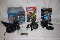 Three holiday light projectors with boxes and accessories arranged together.