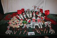 Wide top-down photo showing all items laid out including multiple Sox monkeys, candy canes, gingerbread men, red bead garlands, elephants, penguins, llamas, and snowmen.