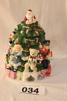 Full front view of the Spode Christmas tree ceramic cookie jar showing detailed figurines and colorful decorations around the base and Santa figure on top.