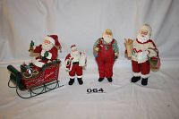 Four vintage Clothique Santas from Possible Dreams Ltd. arranged side by side on white background including musical sleigh Santa, Santa with baby, Santa with toys, and Santa with bread.