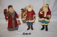 Photo showing front view of three Santa figurines by Possible Dreams Ltd. arranged side by side. Each Santa is distinct in clothing and accessories with detailed facial features.
