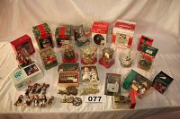 Wide view of the entire lot showing multiple boxed and loose ornaments including figures, trains, and vehicles arranged on a table.