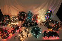 Twelve assorted mini light sets illuminated, showing variety of colors and bulb types with green wires throughout. All lights are on and functional.
