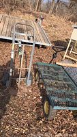 Photo showing the handtruck and garden cart side by side on leaf-strewn ground outdoors.