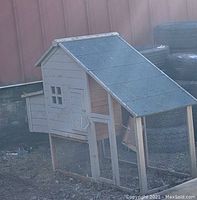 Front-right side view showing entire coop and attached run under pitched roof
