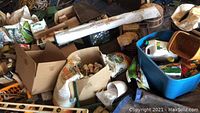 Overview photo showing a large assortment of gardening supplies including multiple bags, boxes, and containers.