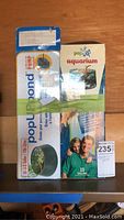 Front view of two pop up pond aquariums in original boxes with green tape.