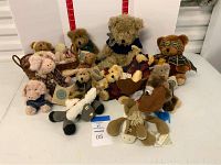 Group of 11 plush toys including Boyds Bears and other brands with tags and varying outfits shown on white background with red measurement scale