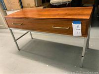 Full view of table showing wood veneer top, drawer and chrome legs