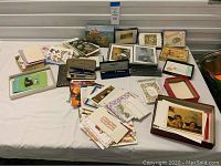 Wide view of tabletop covered with assorted greeting cards, thank you notes, envelopes, and pen boxes.
