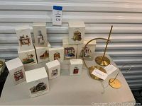 Multiple Hallmark Keepsake Christmas ornament boxes displayed together with two Frontgate metal ornament stands beside them, showcasing original packaging and display accessories.