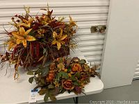 Wide view showing the artificial floral fall centerpieces including the wagon arrangement and floral cluster on table