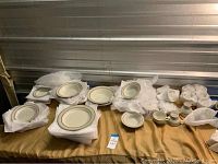 Photo showing Mikasa Stone Craft dishes laid out on table with packing materials