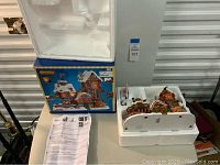 Photo showing the Lemax Elf Made Toy Factory placed in styrofoam packaging with original box and an instruction sheet.