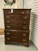 Front view of chest-on-chest dresser showing seven drawers and brass bail handles