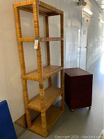 Front view of the tall wicker shelf and the rolling cabinet beside it.
