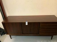 Front view of rosewood credenza showing sliding doors on left and drawers on right.