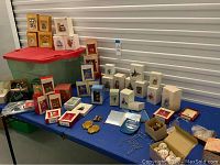 Overview of ornaments and storage bin on table, ornaments in original boxes grouped and storage bin visible.