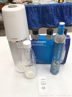 Photo shows SodaStream carbonation machine, single 1L carbonating bottle attached, blue box with 3 bottles, and CO2 canister.
