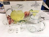 Clear glass margarita pitcher and glasses in front of original box showing Libby branding and 7-piece Cancun Margarita set name.