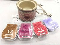 Electric potpourri crock with vintage pink floral design and four sealed Scentsy wax bars arranged in front
