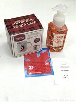 Overview of all items on white surface: coffee mug box, hand soap bottle, PetroCan $25 gift card
