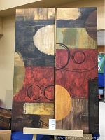 Pair of modern abstract art canvas prints with warm tones and geometric shapes, displayed side by side.