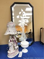 Overall view of the lamp beside the candy dish on a table with a black framed mirror behind