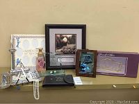 Overview of the daughter plaque, Bath & Body Works soap, necklaces, framed picture, and decorative shelf