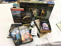 Four Harry Potter VHS tapes, Lord of the Rings DVD collection, Disney 1000-piece puzzle box, and fantasy books with visible titles including works by Diana Wynne Jones and J.R.R. Tolkien.