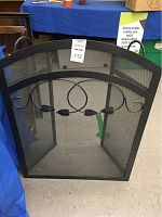 Front view of the main curved black metal fireplace screen with mesh and leaf decoration