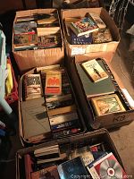 Overview photo showing six large boxes filled with various vintage paperback and hardback books in shelf condition.