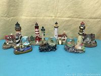 Full set of 7 lighthouse sculptures and 3 snowglobes arranged together with a plain background for clear display.