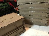 Close-up of two tubs stacked with slide latch lids showing locking mechanism and textured surface.