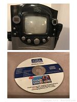 Front view of the Singing Machine karaoke player showing screen, control knobs, and attached microphone.