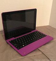 Purple 10-inch RCA tablet attached to black keyboard on purple base, front angled view